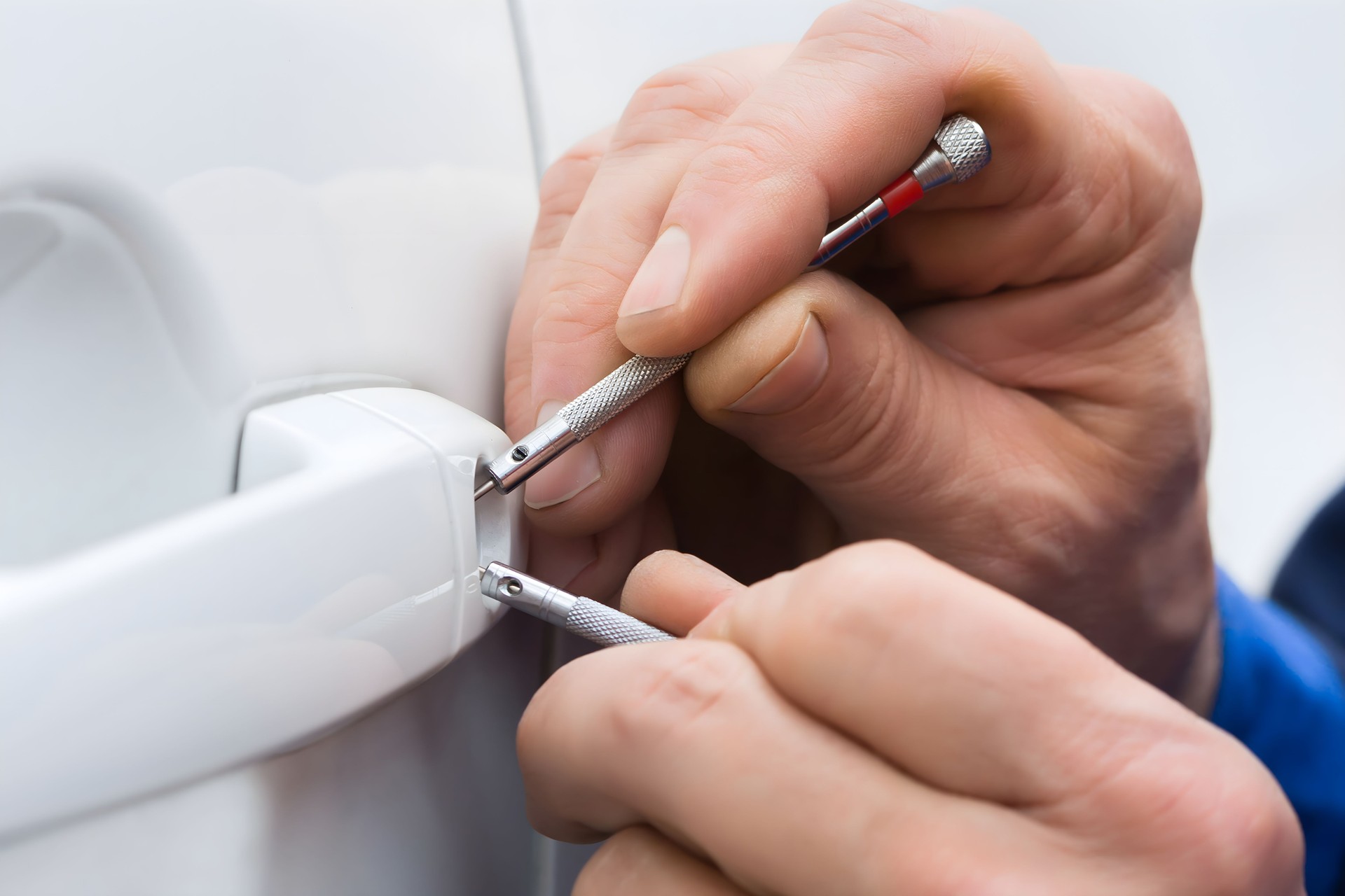 Hand Holding Lockpicker To Open Car Door